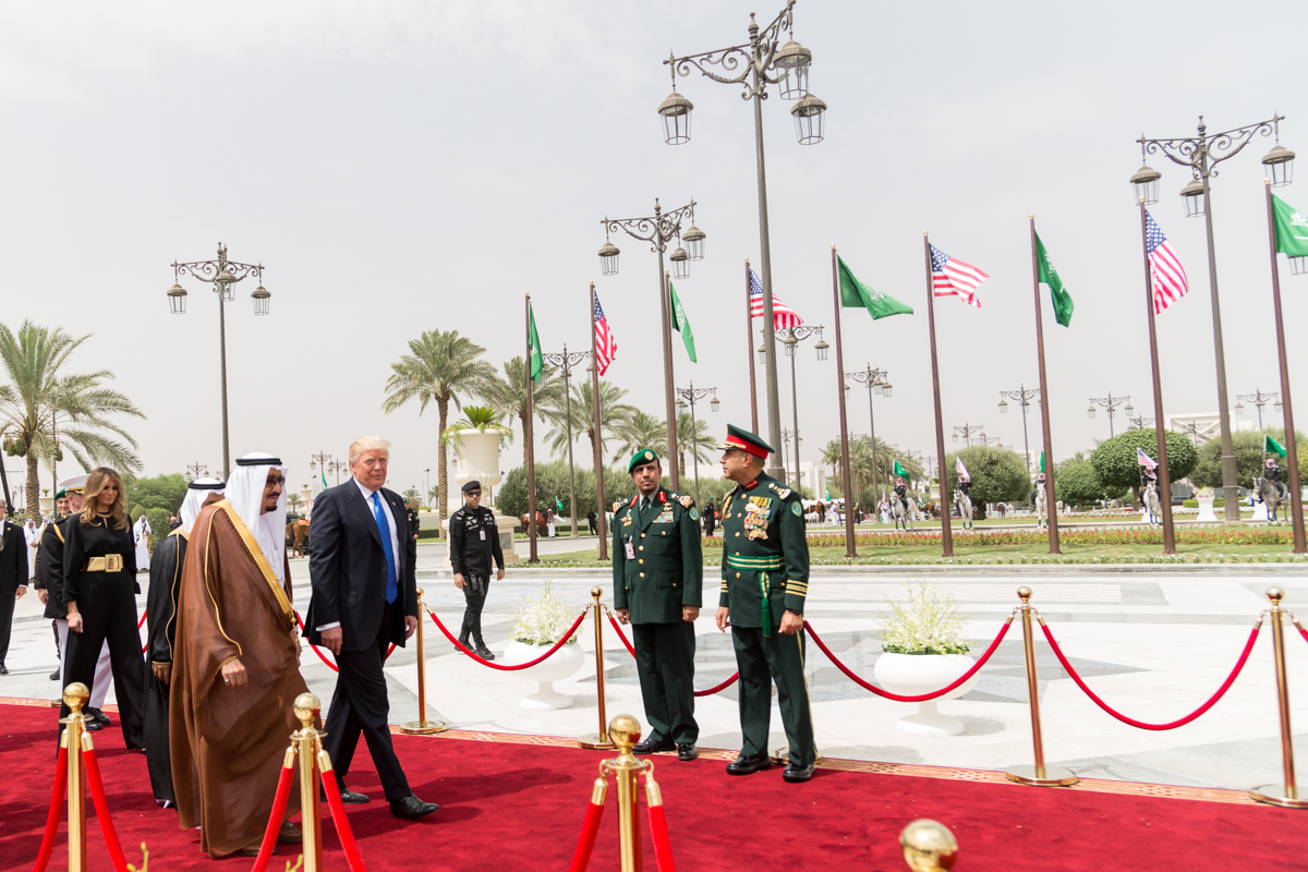 President Trump walks with King Salman bin Abdulaziz Al Saud of Saudi Arabia during state visit welcoming ceremony, Riyadh, May 2017. American and Saudi flags line the red carpet.