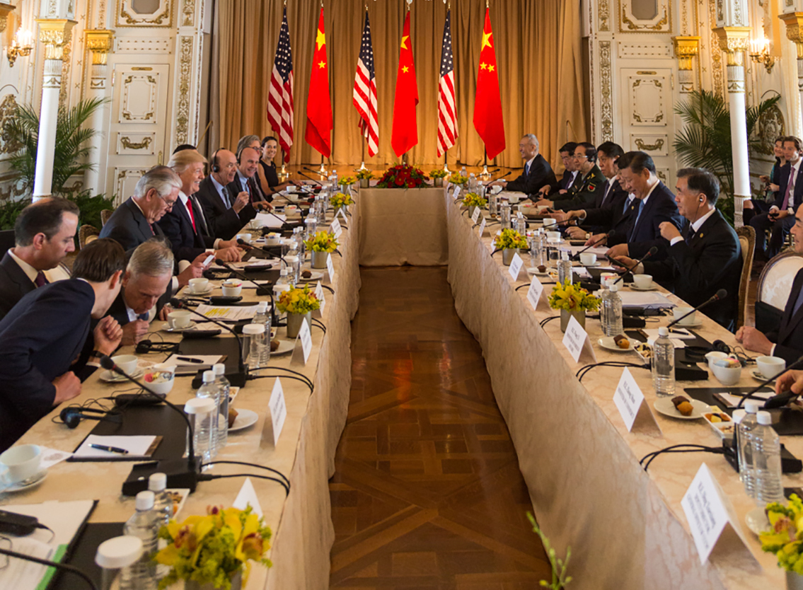 Donald Trump and Xi Jinping lead expanded bilateral delegations at Mar-a-Lago, April 2017, US and Chinese flags behind both sides.