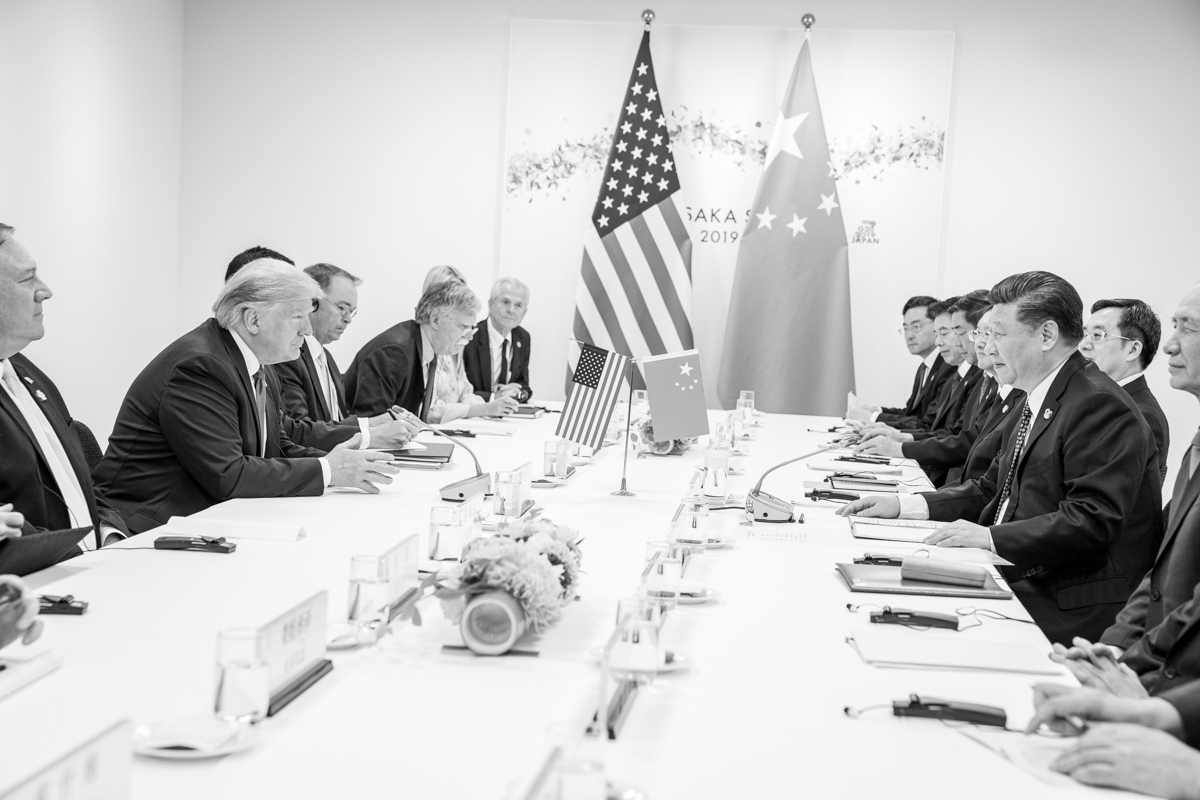 President Trump and Xi Jinping face each other across a bilateral table at the G20 in Osaka, June 2019 — the last major US-China summit before the May 14-15 Beijing meeting that anchors the current diplomatic sequence