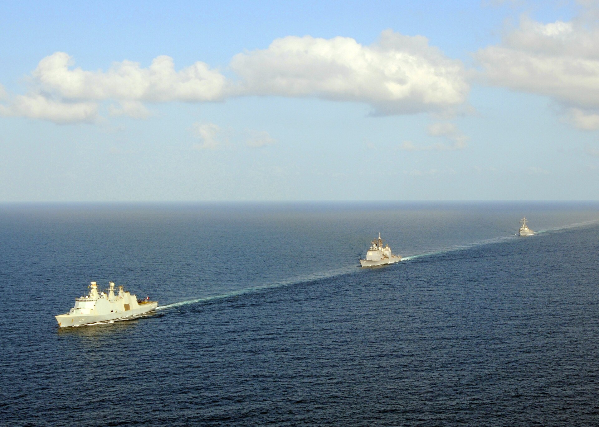 US Navy coalition warships including USS Vella Gulf cruiser and USS Mahan destroyer transit the Gulf of Aden in formation — the waters connecting Bab al-Mandab to the Arabian Sea that no US-Iran ceasefire framework governs