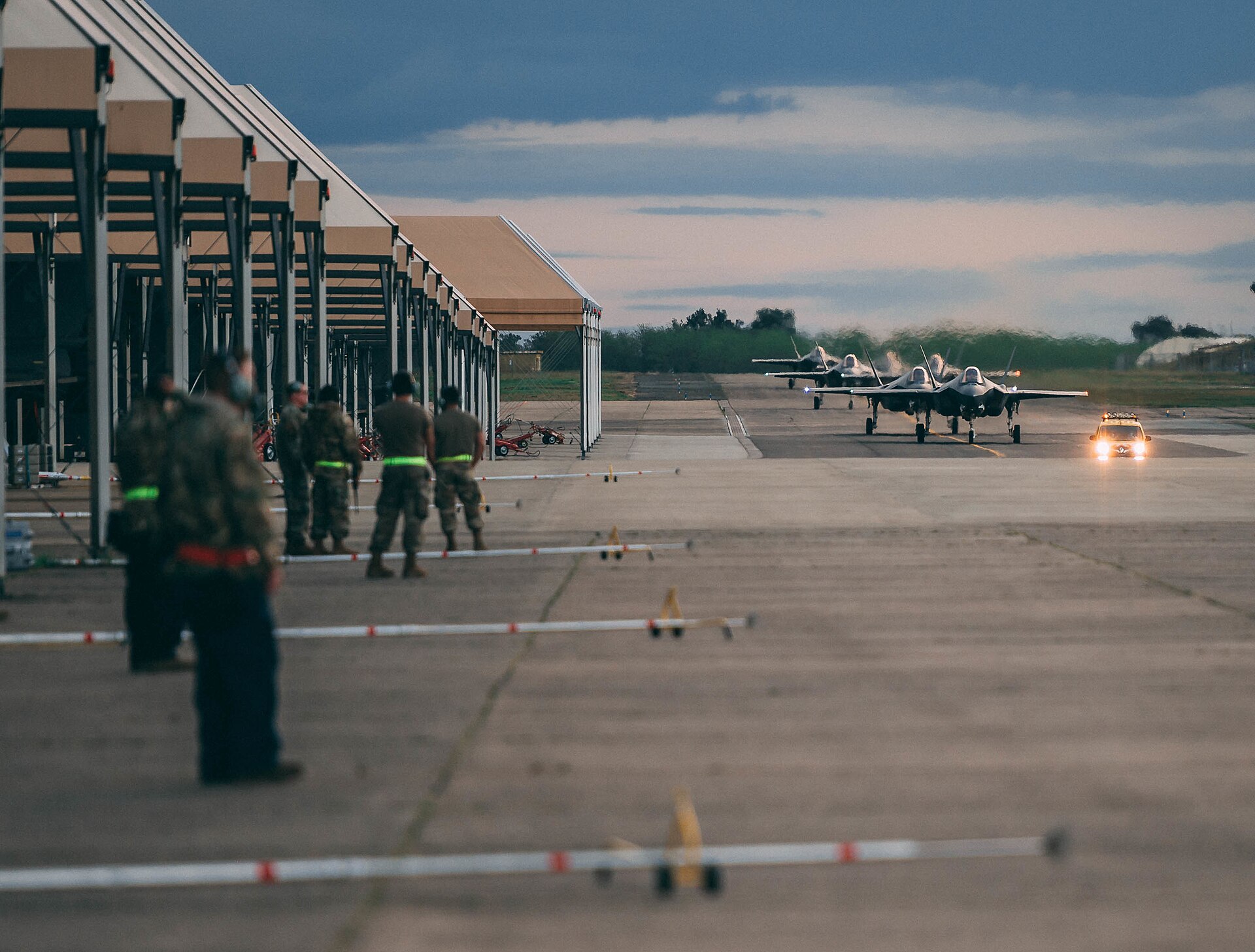 USAF F-35A Lightning II fighter jets taxiing on flight line at air base — same type of aircraft stationed at Al Dhafra UAE