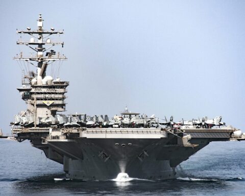 USS Eisenhower CVN-69 aircraft carrier transiting Strait of Hormuz with flight deck aircraft visible