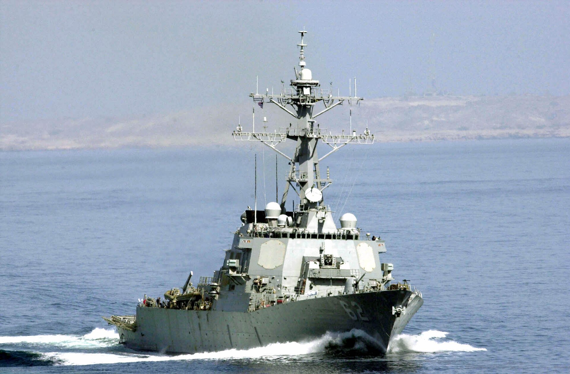 USS Fitzgerald (DDG-62) guided-missile destroyer transiting the Strait of Hormuz, with the arid coast of Iran or Oman visible in the background