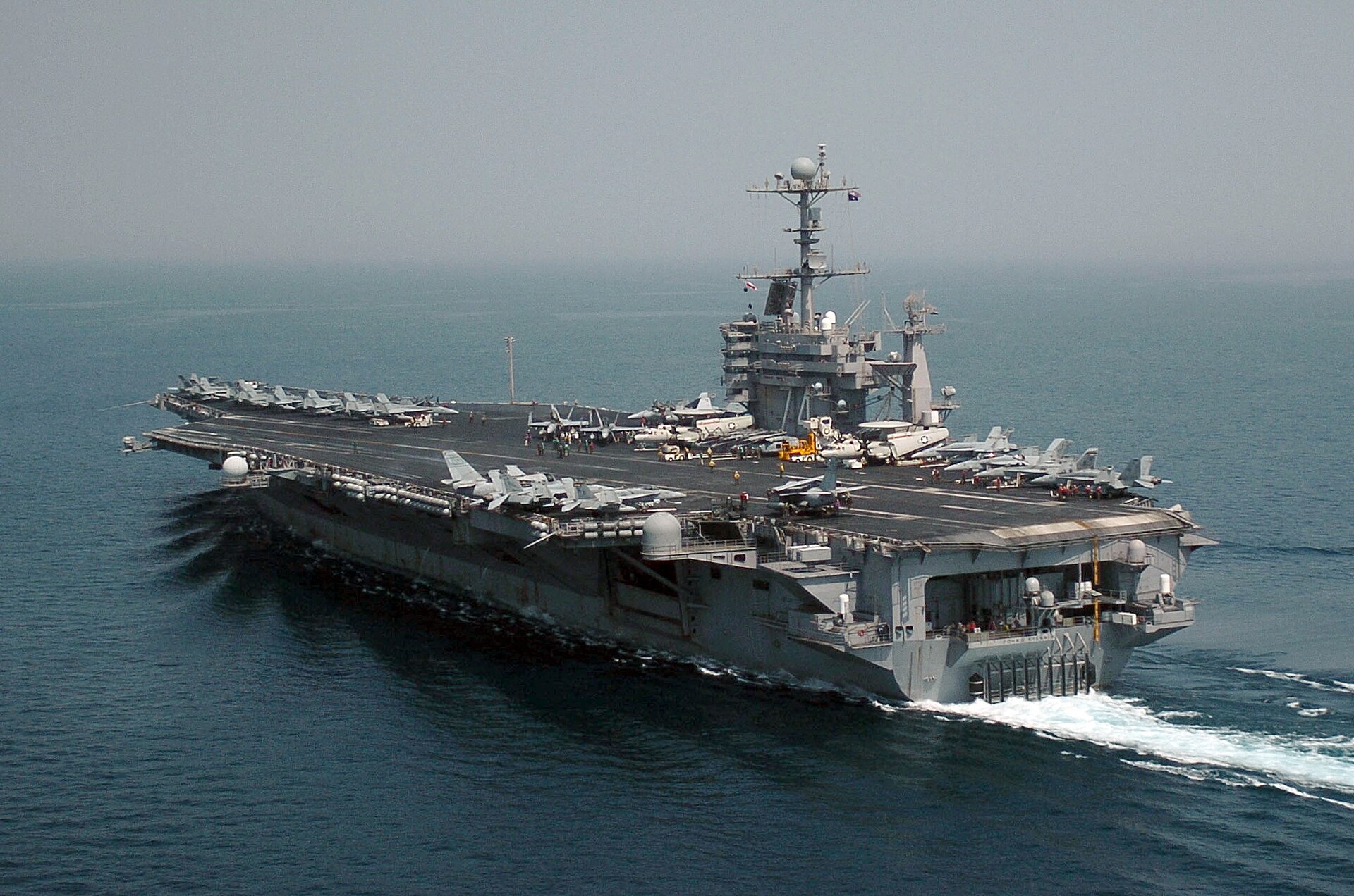 USS John C. Stennis (CVN-74) Nimitz-class aircraft carrier transiting the Persian Gulf with F/A-18 strike fighters on deck — the platform class that would execute renewed strikes on Iranian nuclear infrastructure
