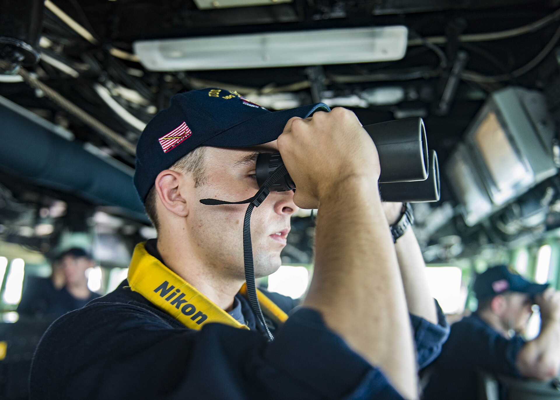 Officer of the Deck stands bridge watch with binoculars aboard USS Stout (DDG 55) during a Strait of Hormuz transit, June 2016