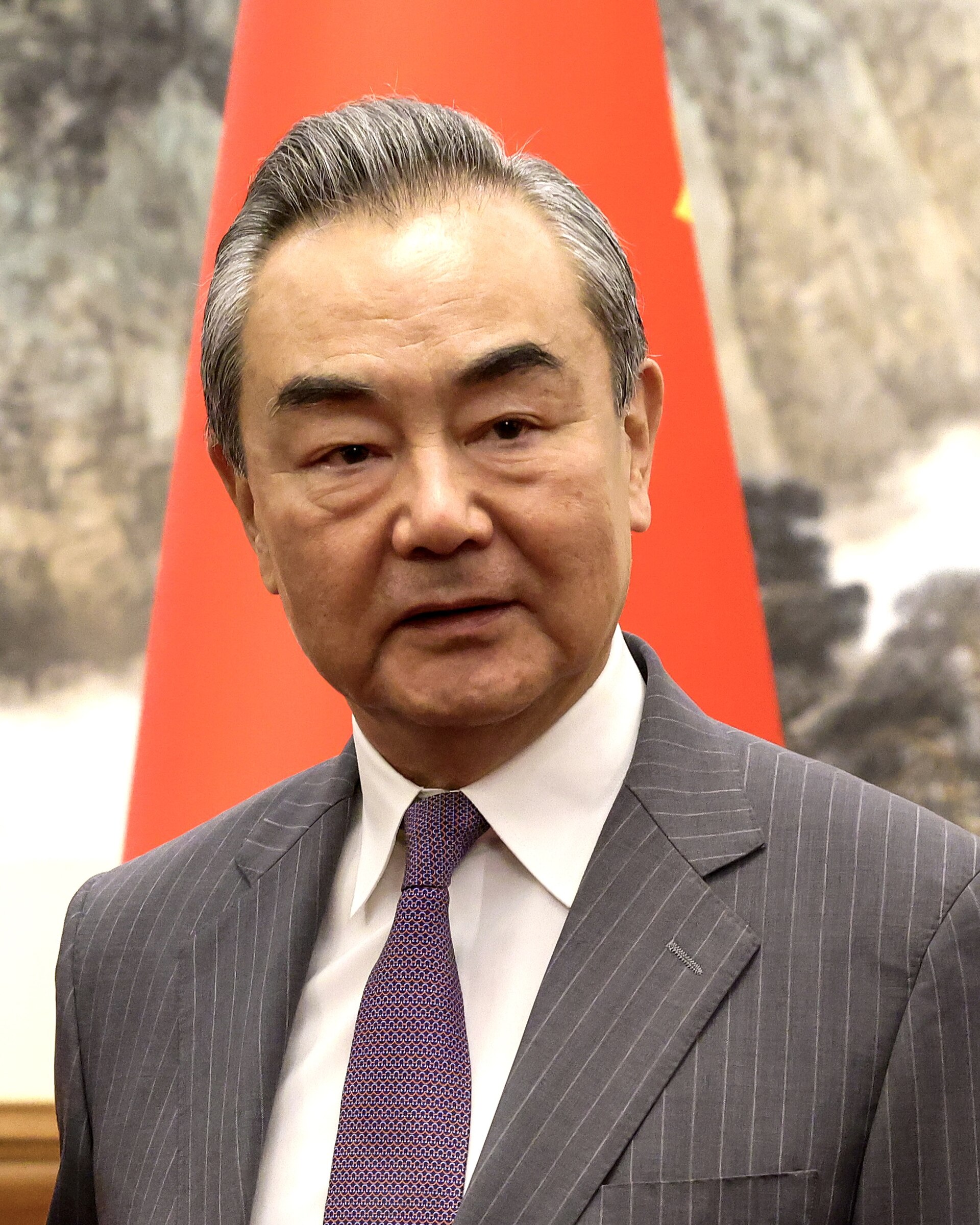 Wang Yi, China Foreign Minister, speaking at diplomatic meeting with Chinese flag in background, Beijing 2023