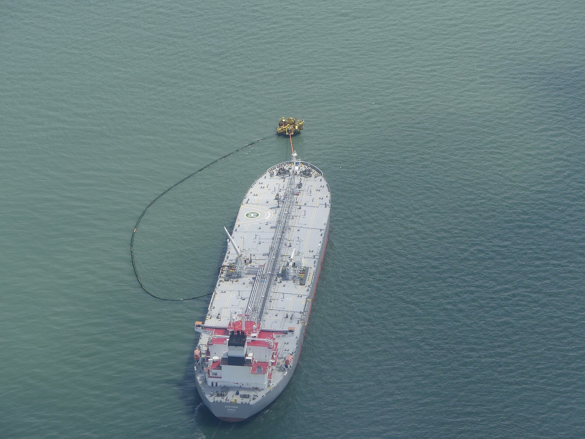 Aerial view of crude oil tanker Strymon connected to a monobuoy loading terminal, showing VLCC loading operations at sea