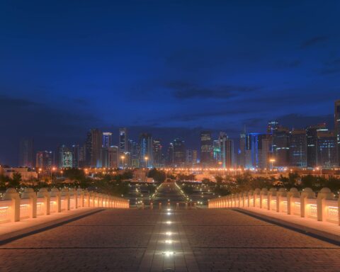 Doha West Bay skyline at night viewed from Mohammed bin Abdulwahab Mosque forecourt, Qatar — venue for US-Iran diplomatic contacts under Qatar mediation