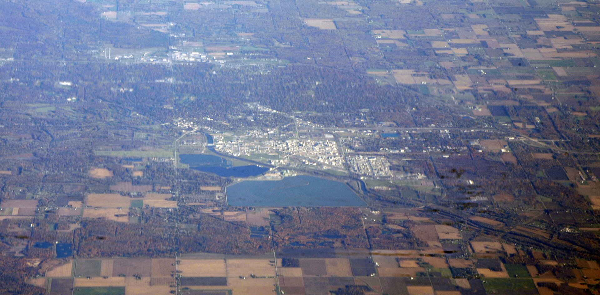Aerial view of Midland, Michigan showing the Dow Chemical Company plant and headquarters complex — the white industrial areas visible in the upper portion of the image