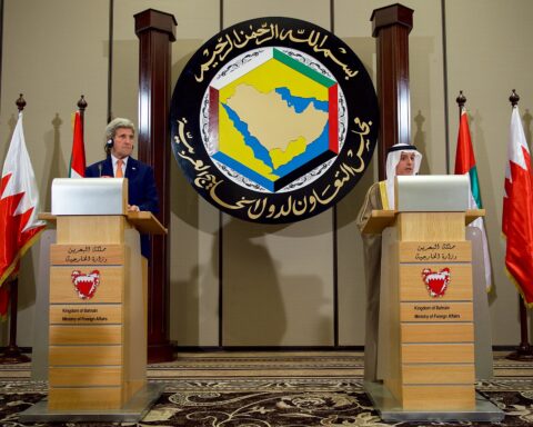 GCC Secretary General and Saudi Foreign Minister al-Jubeir at podiums with GCC emblem behind them, Bahrain Ministry of Foreign Affairs, Manama — Gulf Cooperation Council ministerial press conference