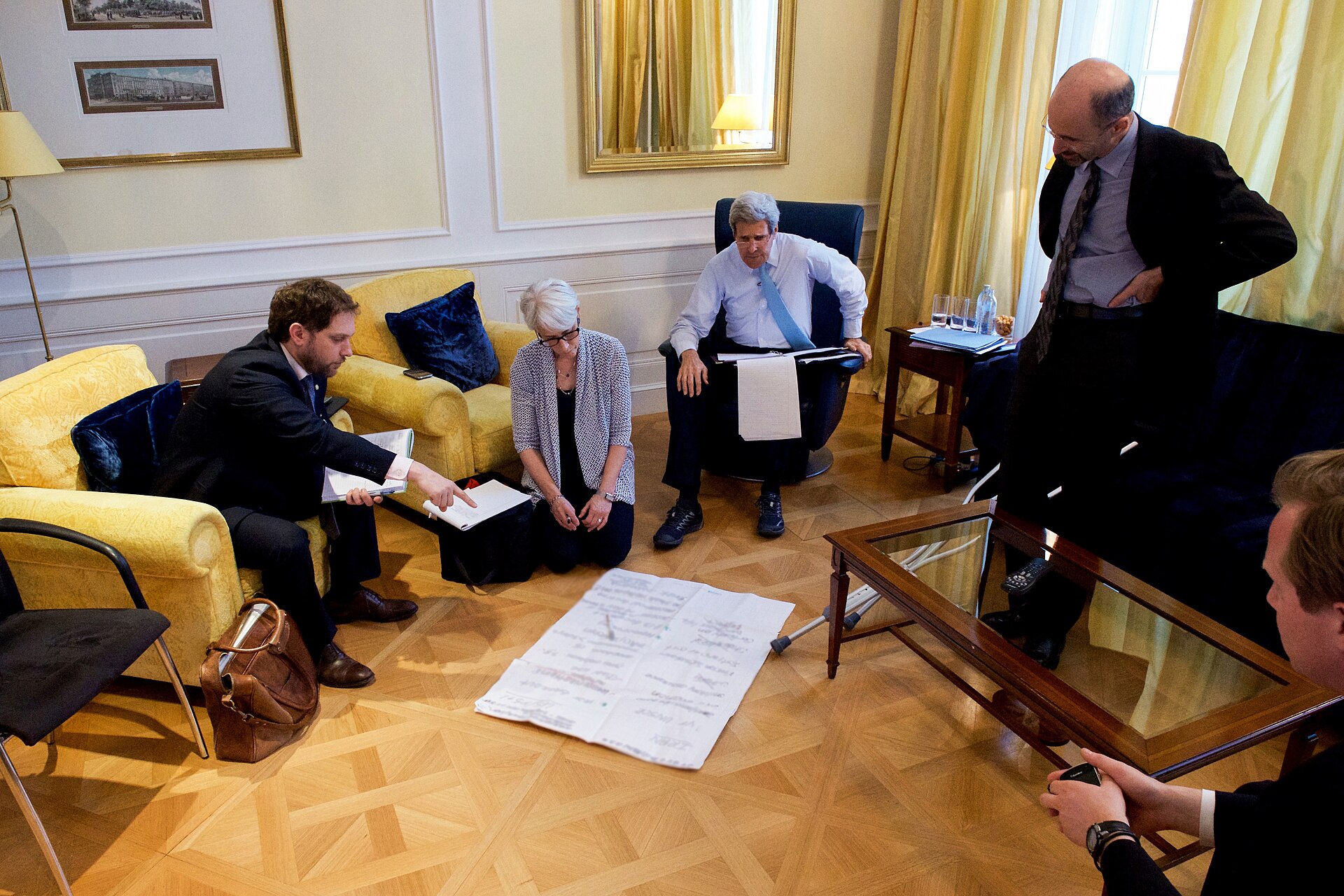 Under Secretary Wendy Sherman kneeling on the floor with Secretary Kerry reviewing a poster-board checklist of remaining items to negotiate at the Iran nuclear talks in Vienna July 2015