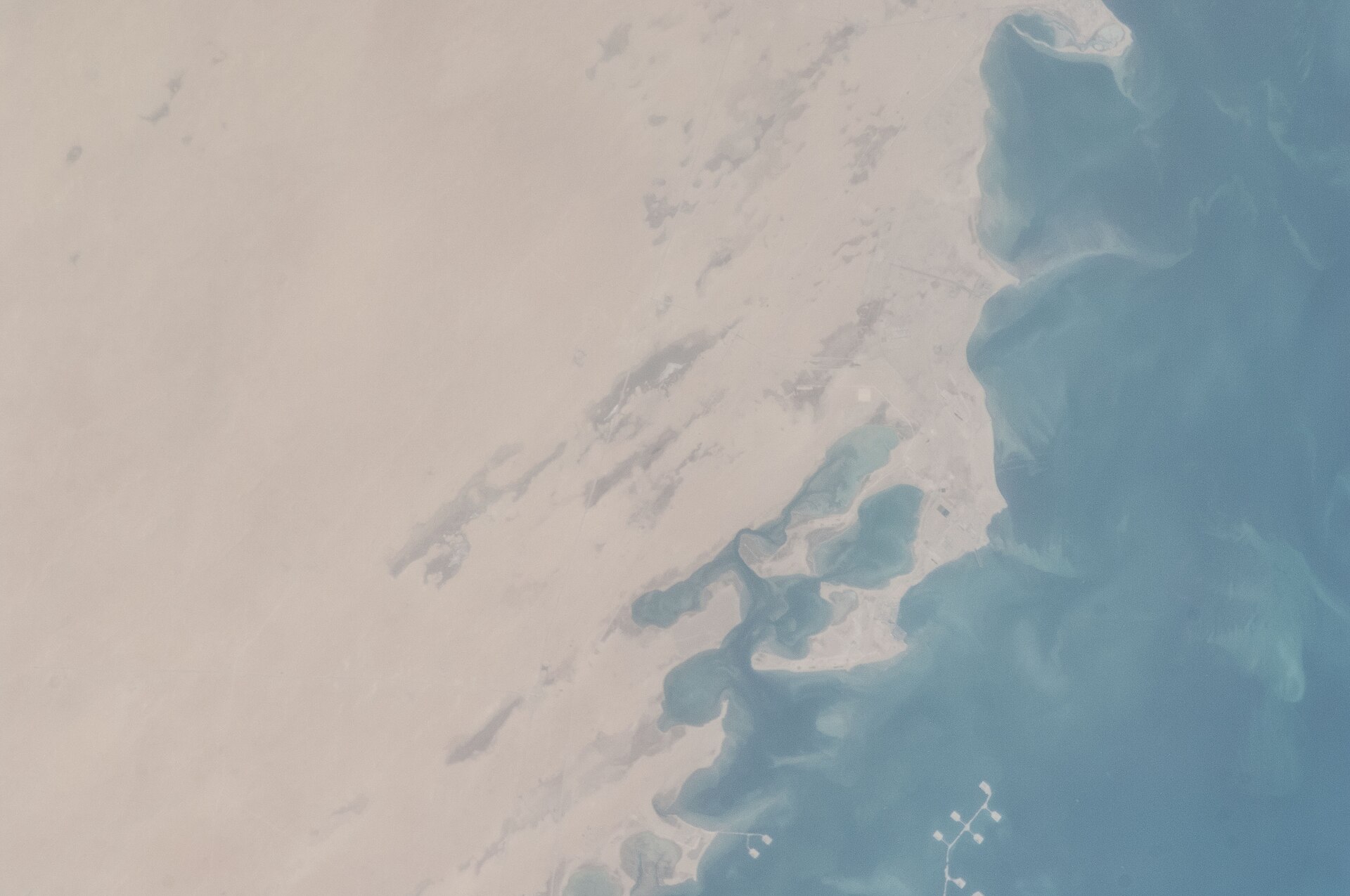 ISS Expedition 35 satellite view of Saudi Arabia Eastern Province coastline near Jubail and Ras Tanura, showing oil loading jetties extending into the Persian Gulf