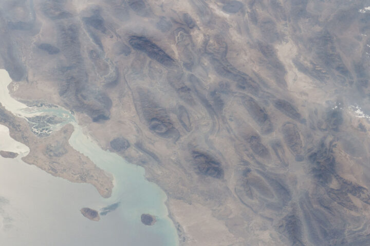 ISS view of Qeshm Island, Larak, and the Strait of Hormuz from ISS Expedition 47 — the Khuran Strait and Qeshm-Larak corridor claimed as PGSA toll zone. Photo: NASA / Public Domain