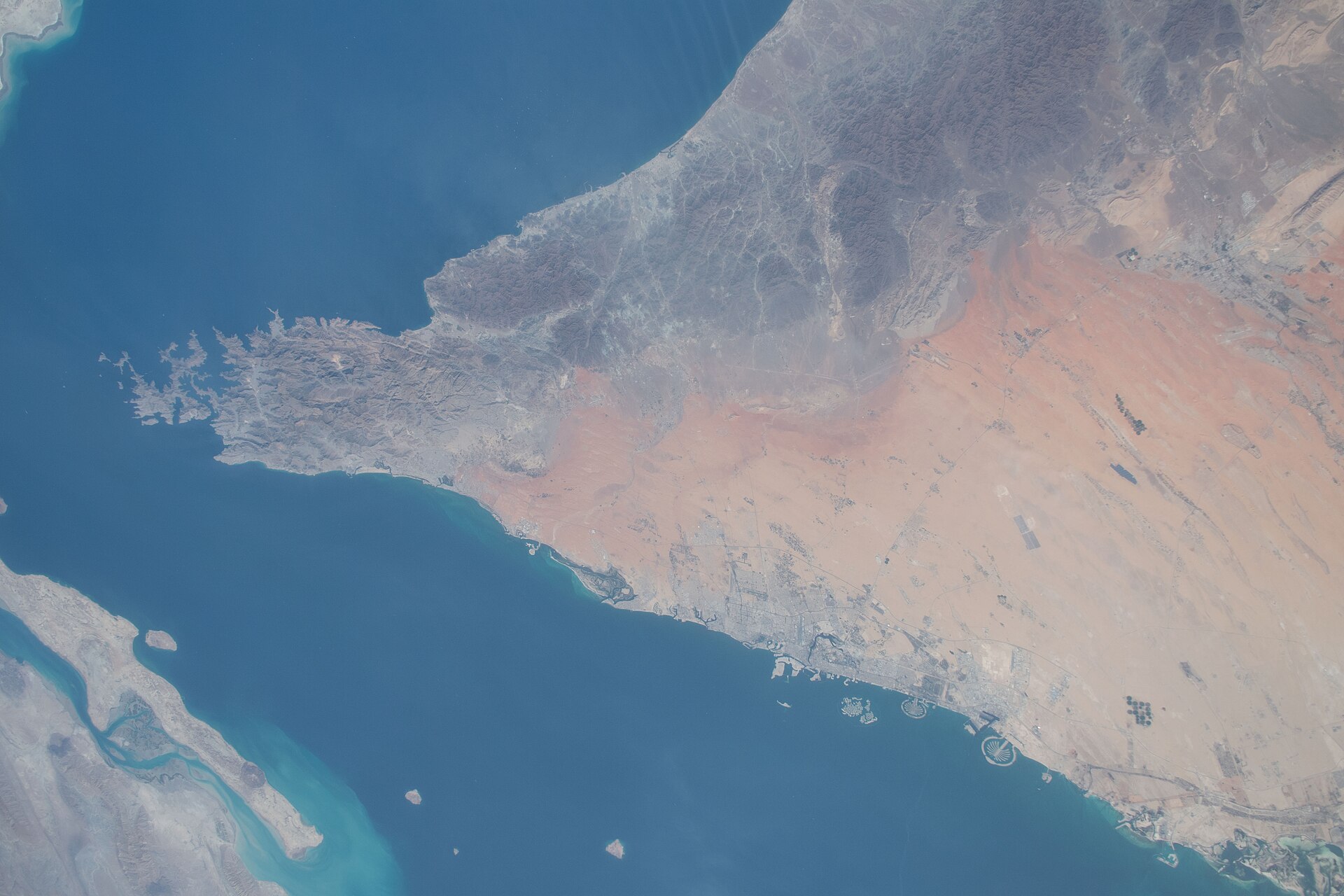 Musandam Peninsula and southern entrance to the Strait of Hormuz photographed from ISS Expedition 59, showing the UAE and Oman coastlines flanking the world most critical oil shipping lane. NASA / Public Domain