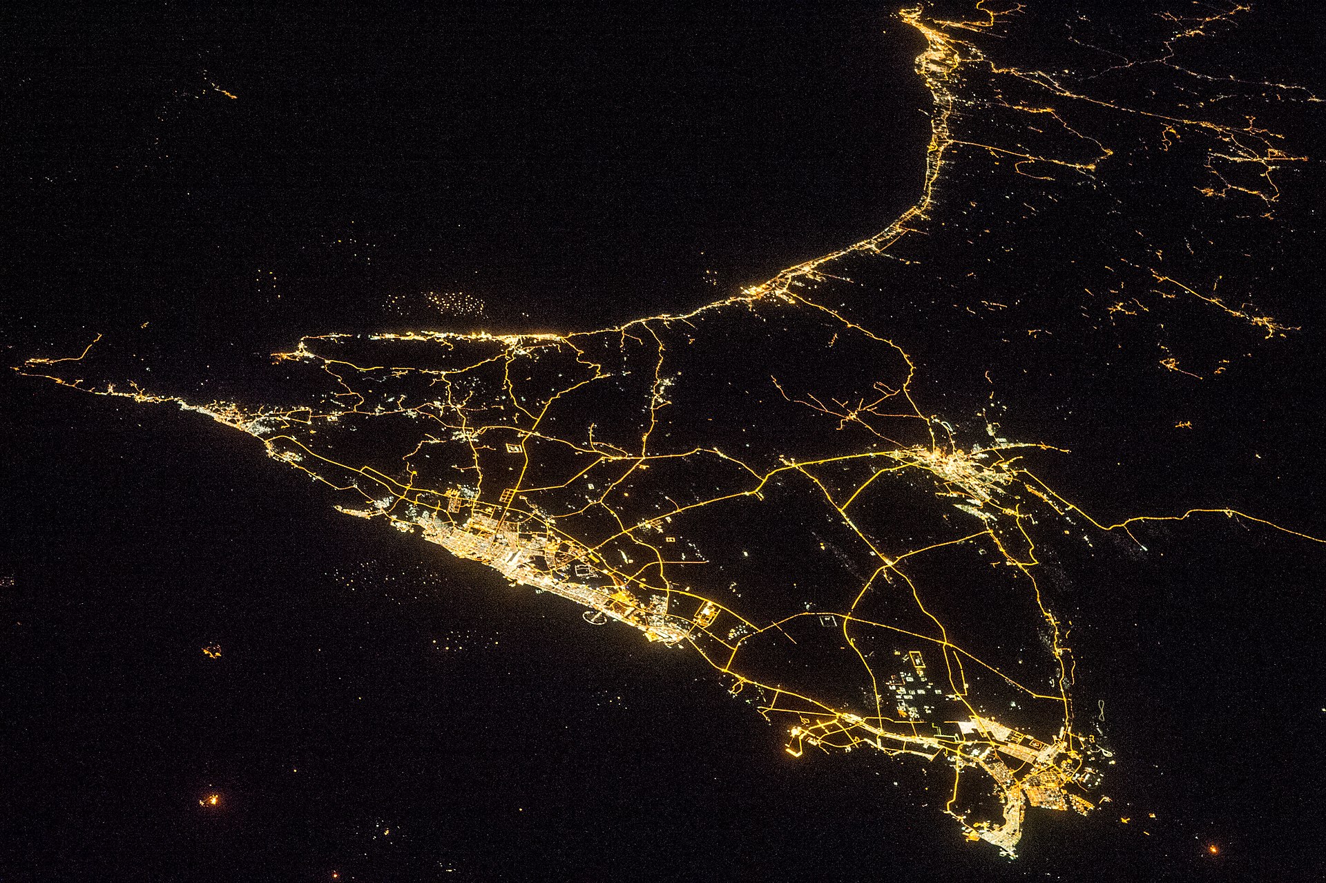 UAE oil-producing states at night photographed from ISS Expedition 38, showing Dubai, Abu Dhabi and the Gulf coast highway network. NASA / Public Domain