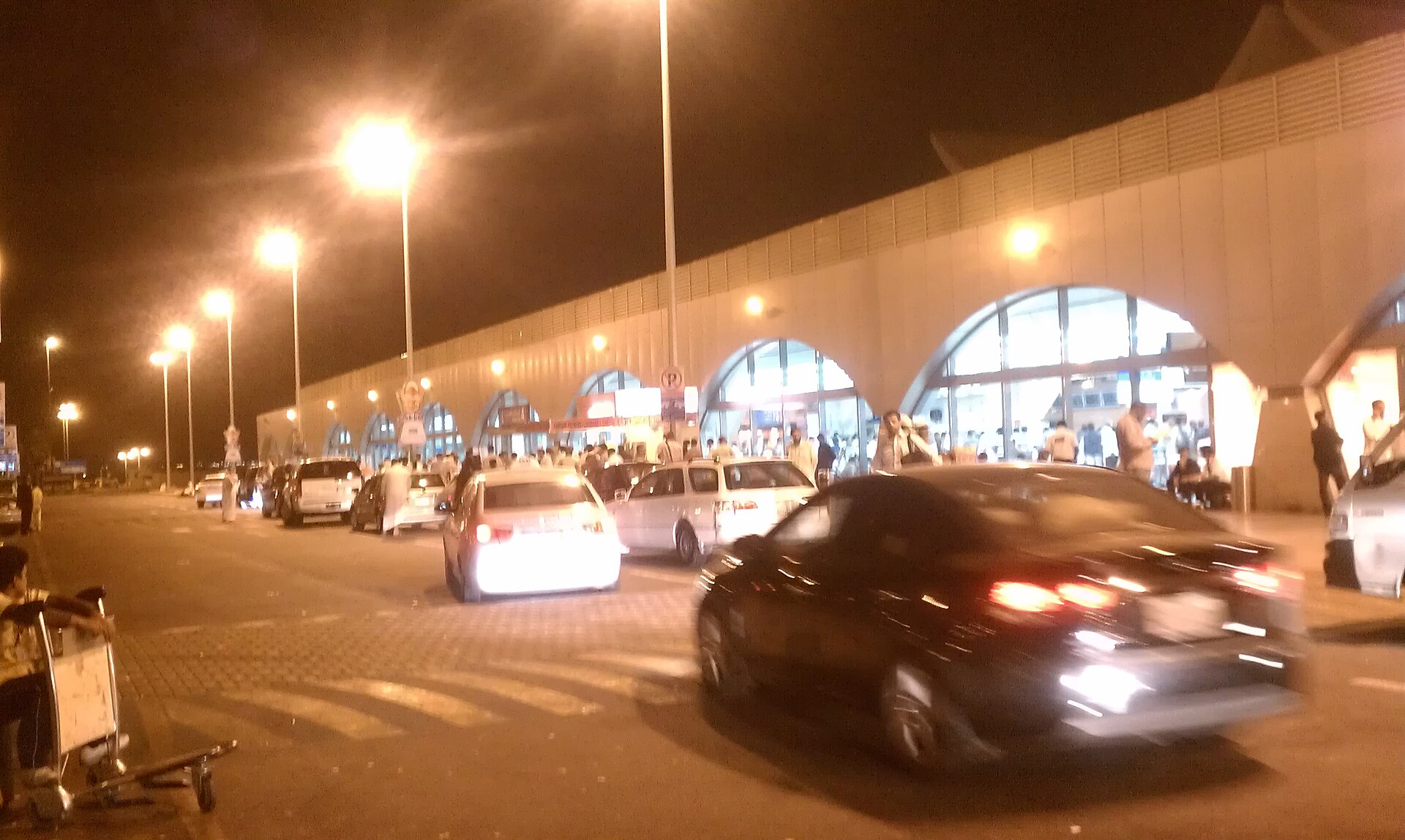 King Abdulaziz International Airport in Jeddah, Saudi Arabia at night with traffic and passengers outside the terminal — Saudi airports remained open on June 3 as Kuwait, Bahrain and UAE suspended commercial flights