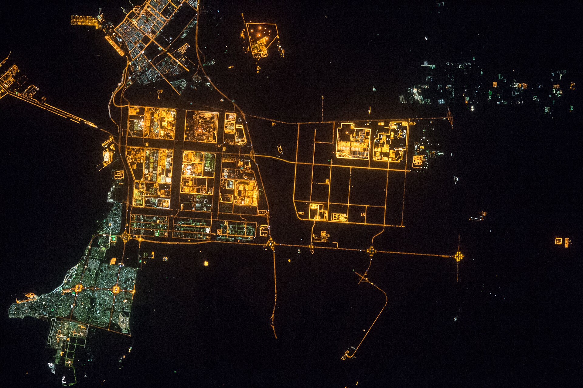 Jubail Industrial City at night photographed from the International Space Station — the glowing industrial grid in the upper centre is the $20 billion Sadara petrochemical complex, with all 26 manufacturing units offline since March 31, 2026. Photo: NASA/ISS Expedition 45 / Public domain