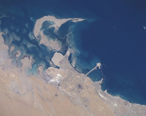 Jubail Industrial City, Saudi Arabia — aerial view from the Space Shuttle showing the petrochemical complex grid and King Fahd Industrial Port on the Persian Gulf coast, June 1996