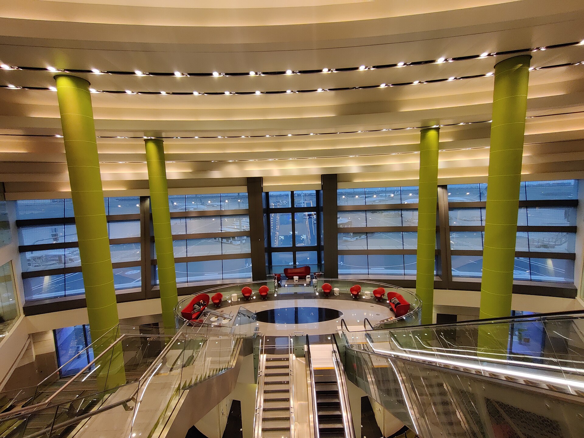 Interior of Kuwait International Airport Terminal 1 showing departure hall with escalators and glass facade overlooking the apron — the terminal struck by IRGC drones on June 3, 2026, forty-eight hours after reopening