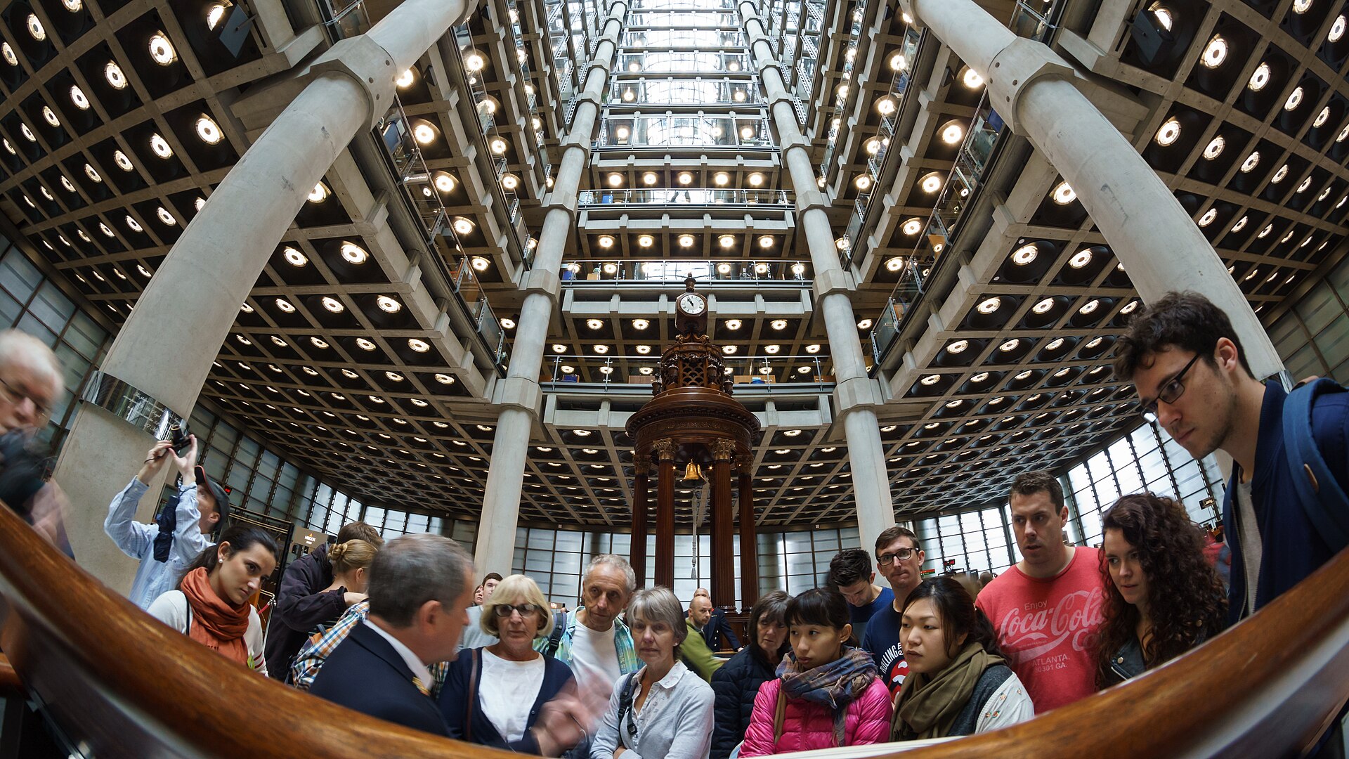 Lloyd's of London underwriting room interior showing the iconic atrium and the Lutine Bell at One Lime Street, where marine war-risk syndicates set insurance rates for global shipping