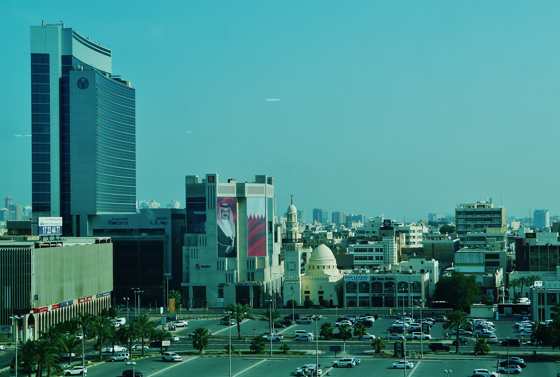 Manama city skyline showing Bahrain Financial Harbour area with mosque and royal portrait, Bahrain