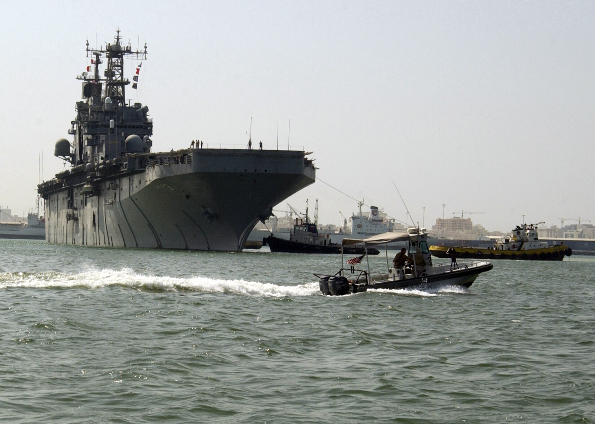 NSA Bahrain harbor patrol unit escorts USS Belleau Wood amphibious assault ship into Mina Salman pier, Manama, Bahrain