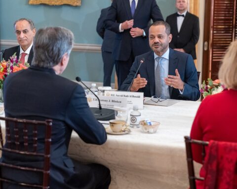 Omani Foreign Minister Badr bin Hamad Al Busaidi speaking at a diplomatic meeting with US Secretary of State Blinken, with his nameplate visible, as Oman serves as the primary intermediary for US-Iran nuclear negotiations