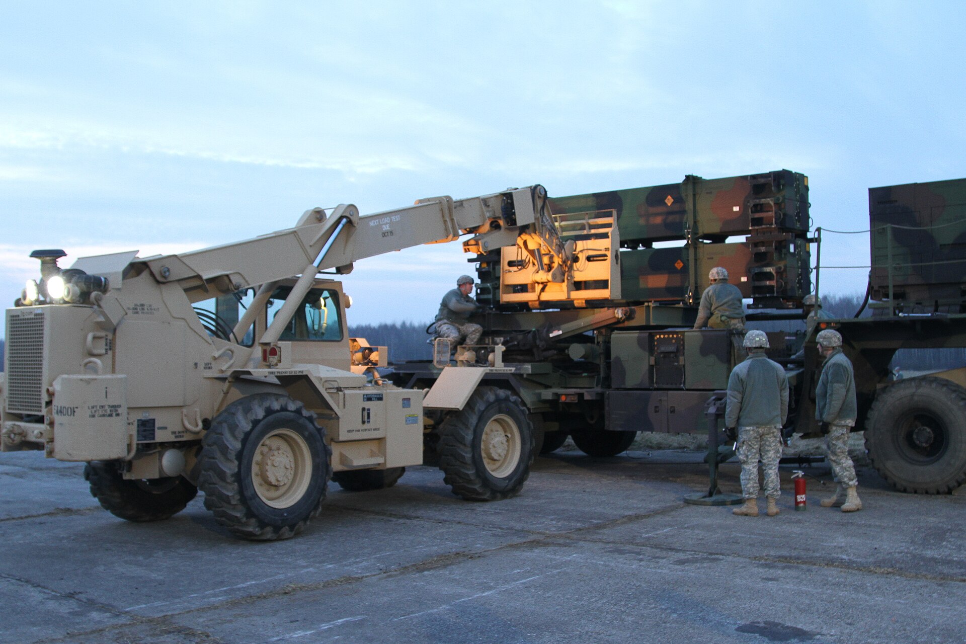 US Army soldiers load PAC-3 Patriot missile canister onto launcher during air defense artillery exercise in Poland
