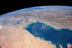 The Persian Gulf photographed from the International Space Station during Expedition 40, showing the full extent of the waterway where approximately 600 vessels were waiting as of June 15, 2026. The Strait of Hormuz narrows to 21 miles at the right of the image. Photo: NASA / Public Domain