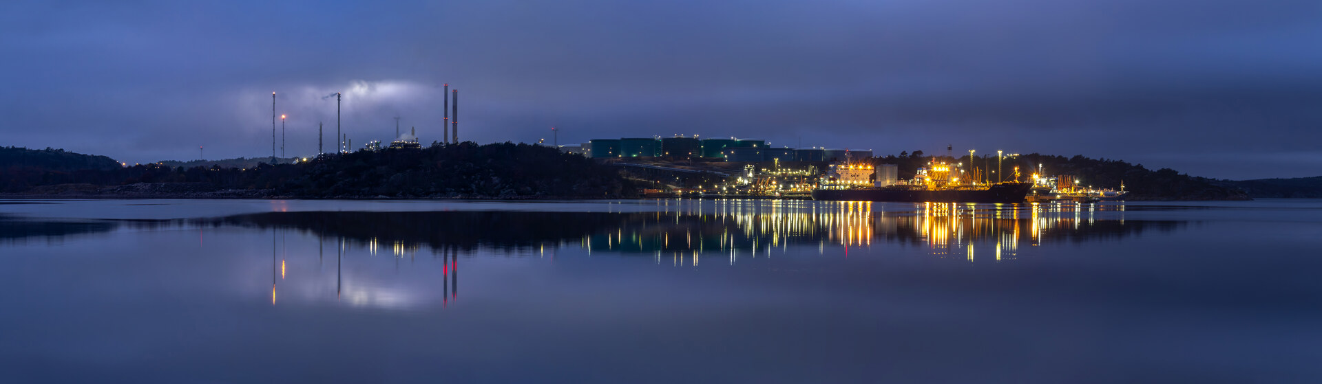 Preemraff Lysekil oil refinery at blue hour reflected in Brofjorden, Sweden. The wartime premium that had lifted Saudi weekly revenue 10 percent above pre-war levels collapsed when Brent fell to $89.15 on a single deal-related statement.