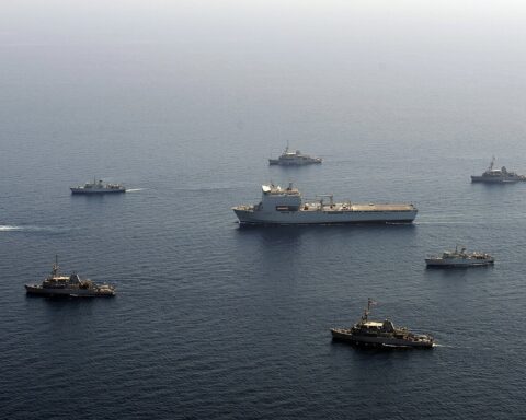 RFA Lyme Bay (center) surrounded by eight British and US Navy mine countermeasures ships in the Arabian Sea — the allied coalition now mobilized for Hormuz clearance that Trump told the G7 he did not need.