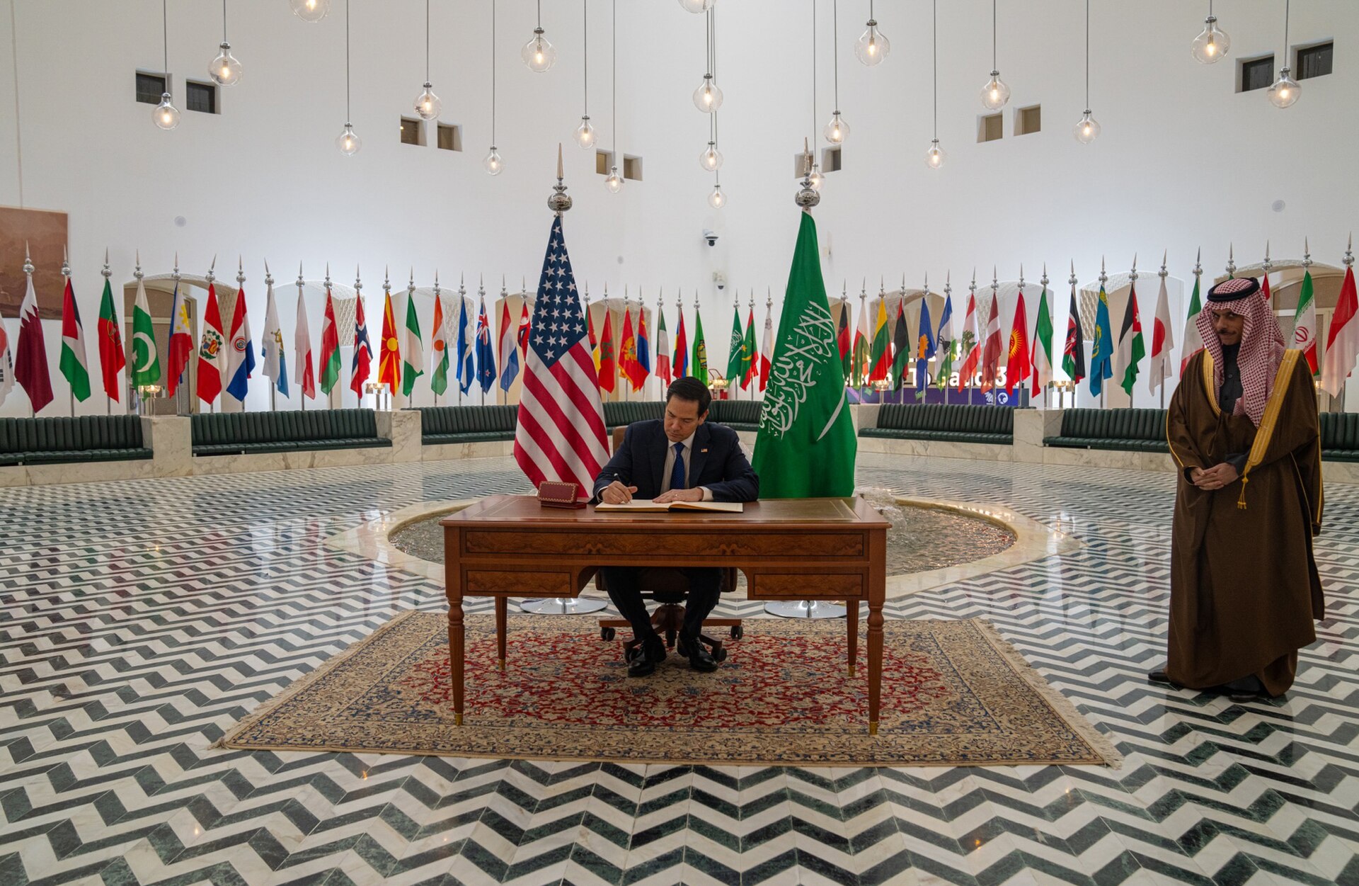 Secretary of State Marco Rubio signs the guest book at the Saudi Ministry of Foreign Affairs in Riyadh while Saudi Foreign Minister Prince Faisal bin Farhan looks on, February 17, 2025