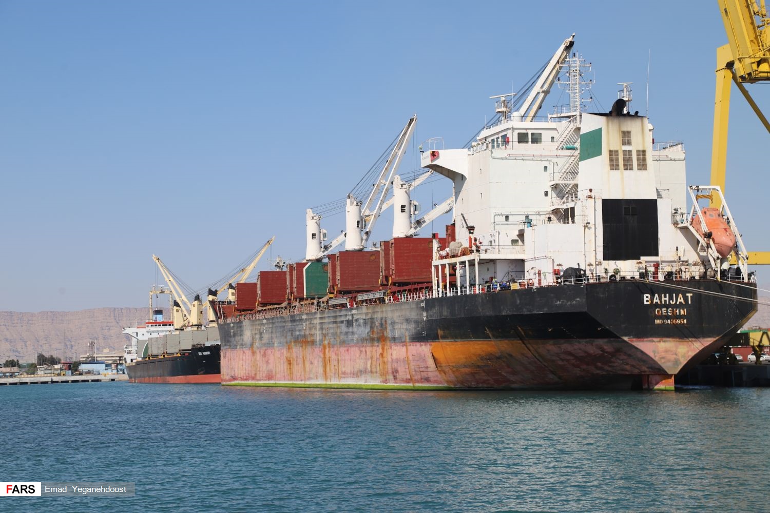 Cargo vessel Bahjat Qeshm docked at Shahid Rajaee Port near Bandar Abbas, Iran — the main commercial port adjacent to the Strait of Hormuz where PGSA transit documentation is processed