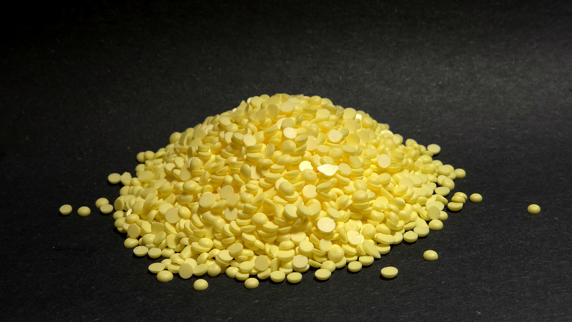 Pile of solid elemental sulfur granules used in fertilizer production — the same processed form exported from Gulf terminals that supply phosphate fertilizer manufacturers including Morocco's OCP Group