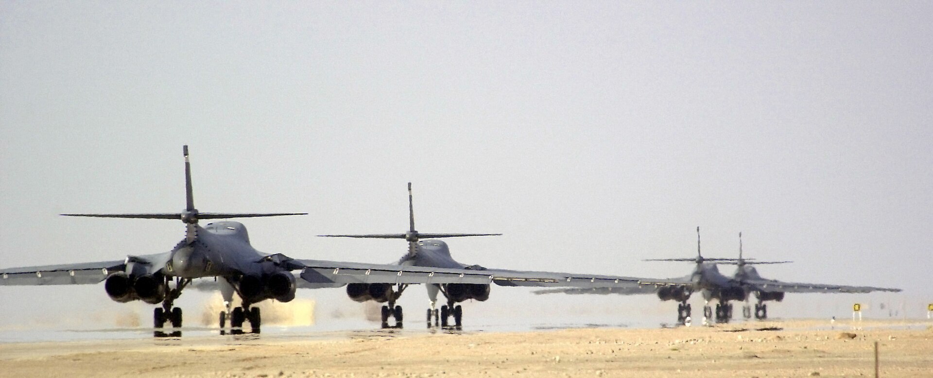 US Air Force B-1B Lancer bombers taxi at RAFO Thumrait Air Base in Oman during Operation Enduring Freedom — the same base whose access agreement prevents Washington from sanctioning Oman's role in Iran's Hormuz fee framework