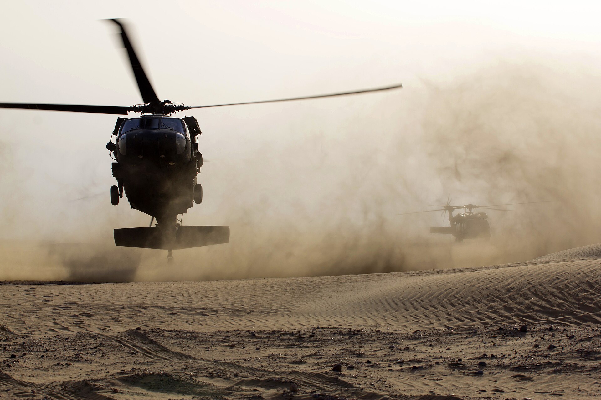 US Army UH-60 Black Hawk helicopters land during a joint live-fire partnership exercise with US Air Force and Kuwaiti Air Force, Kuwait, 2013 — conducted under the 1991 Defense Cooperation Agreement that now functions as the legal on-ramp for emergency-track arms deliveries