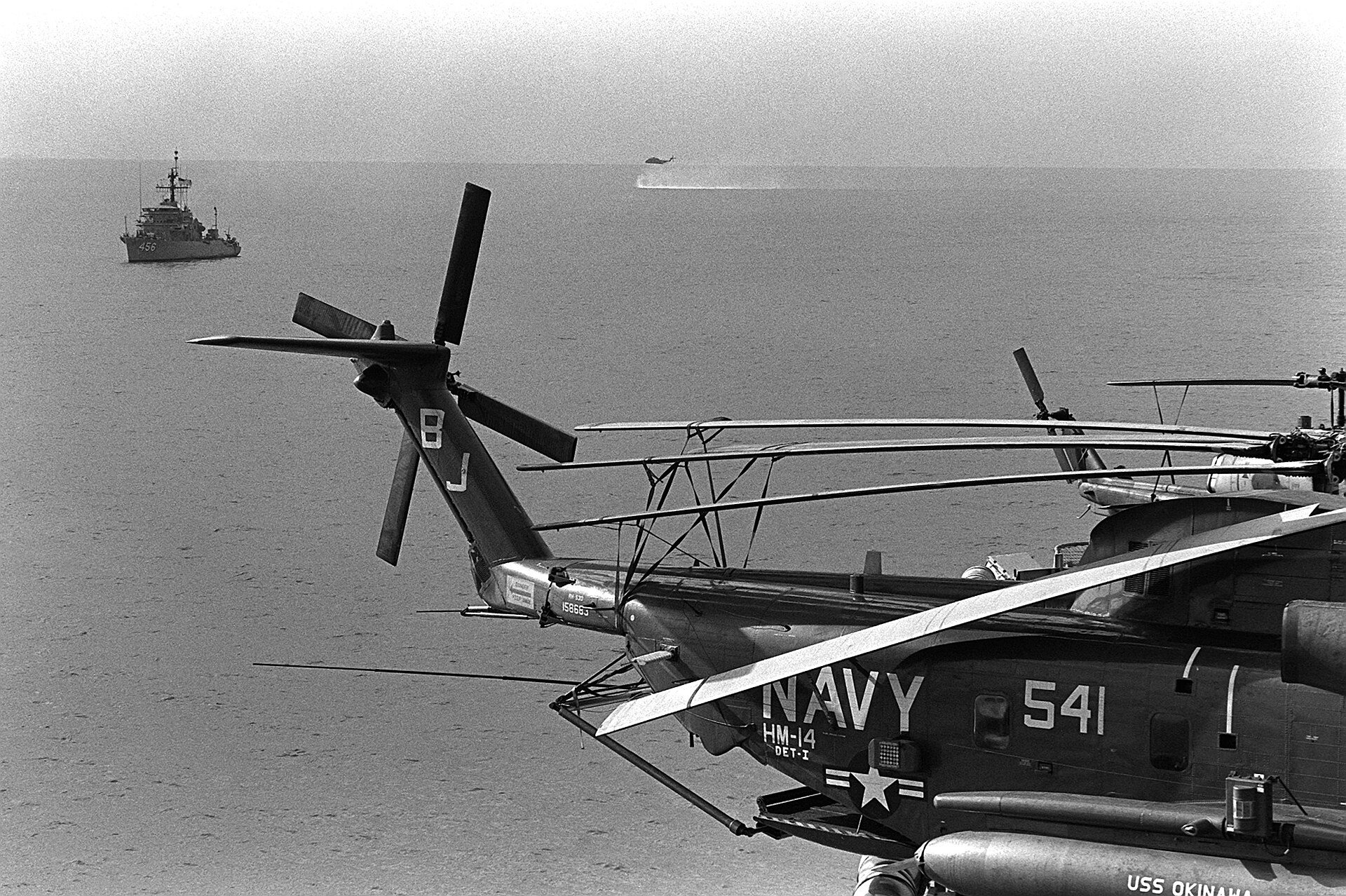 US Navy minesweeper USS Inflict (MSO-456) with a Helicopter Mine Countermeasures Squadron 14 RH-53D Sea Stallion practicing minesweeping in the Persian Gulf, 1987