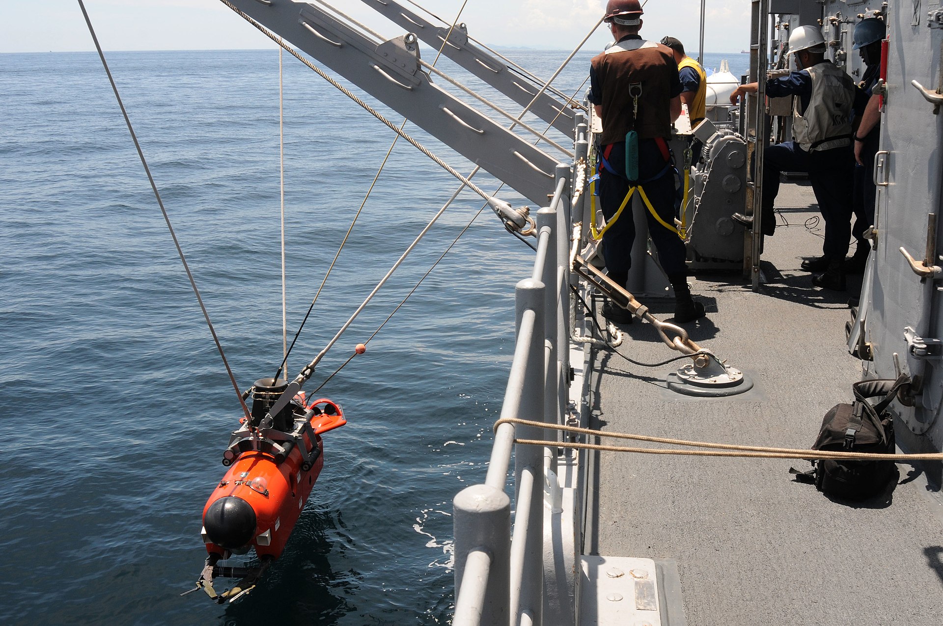 Sailors aboard USS Avenger (MCM 1) lower a mine neutralization vehicle into the water during operations in the Strait of Malacca