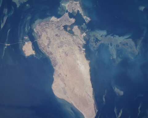 NASA satellite photograph of Bahrain island in the Persian Gulf, showing Manama in the north and the King Fahd Causeway to Saudi Arabia — the island nation where Amazon Web Services ME-South-1 cloud region was struck by IRGC cruise missiles in July 2026