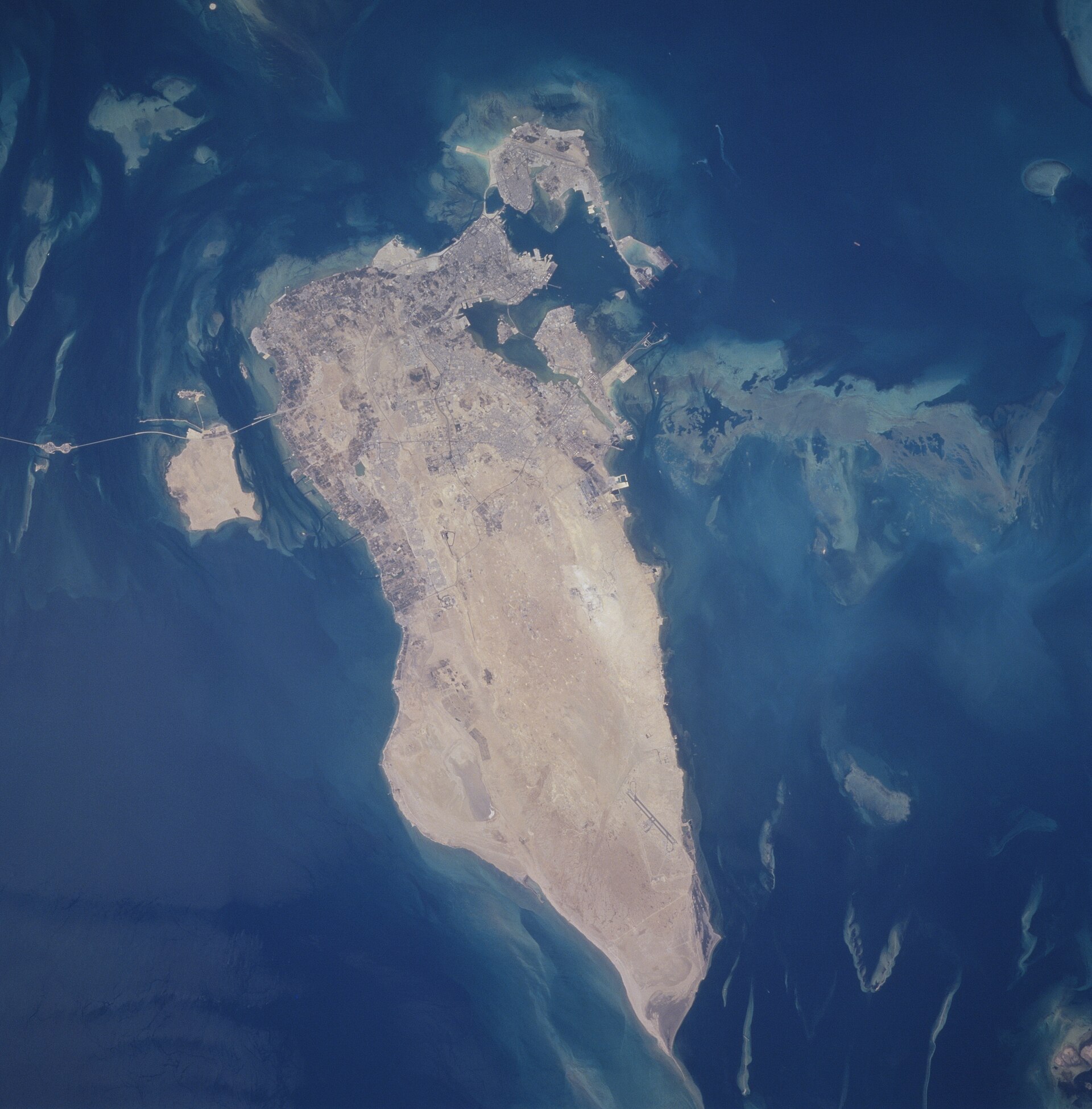 NASA satellite photograph of Bahrain island in the Persian Gulf, showing Manama in the north and the King Fahd Causeway to Saudi Arabia — the island nation where Amazon Web Services ME-South-1 cloud region was struck by IRGC cruise missiles in July 2026
