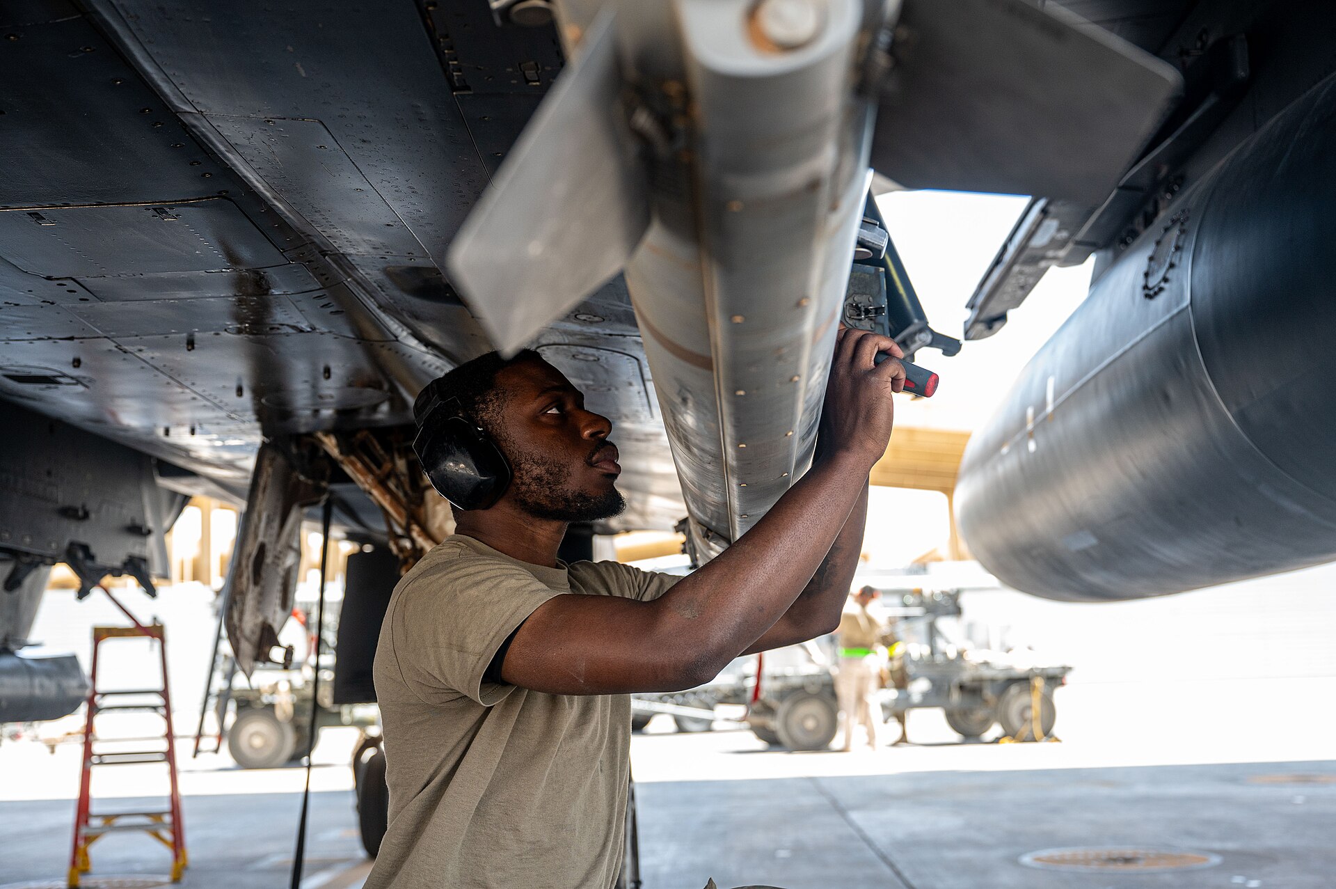 US Air Force Airman securing a precision munition to an F-15E Strike Eagle in the CENTCOM area of responsibility, June 2025