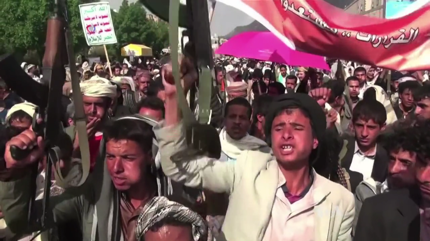 Houthi fighters display rifles at an Ansarullah demonstration in Sanaa, Yemen — the movement that named Saudi Aramco oil infrastructure as a target on July 18, 2026