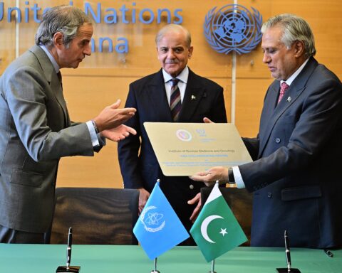 IAEA Director-General Rafael Grossi and Pakistan Deputy PM Ishaq Dar exchange signed agreement at IAEA Vienna headquarters, February 2026, as PM Shehbaz Sharif witnesses