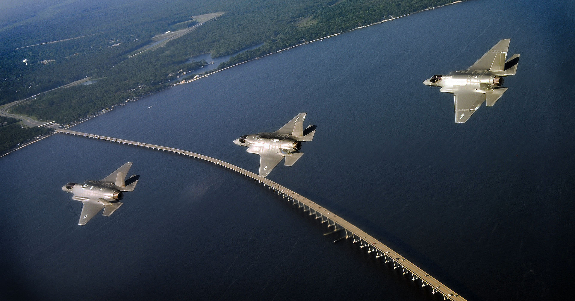 Three F-35 Lightning II variants — F-35A, F-35B, and F-35C — in formation flight near Eglin Air Force Base, May 2014