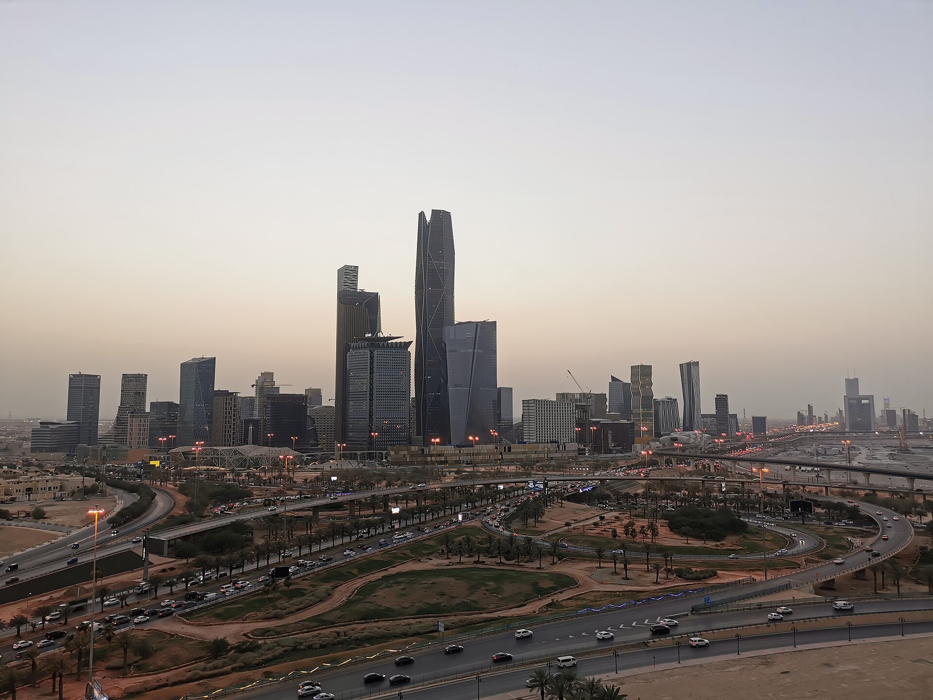 The King Abdullah Financial District (KAFD) in Riyadh illuminated at dusk, showing the cluster of financial towers that anchor Saudi Arabia's Vision 2030 economic ambitions