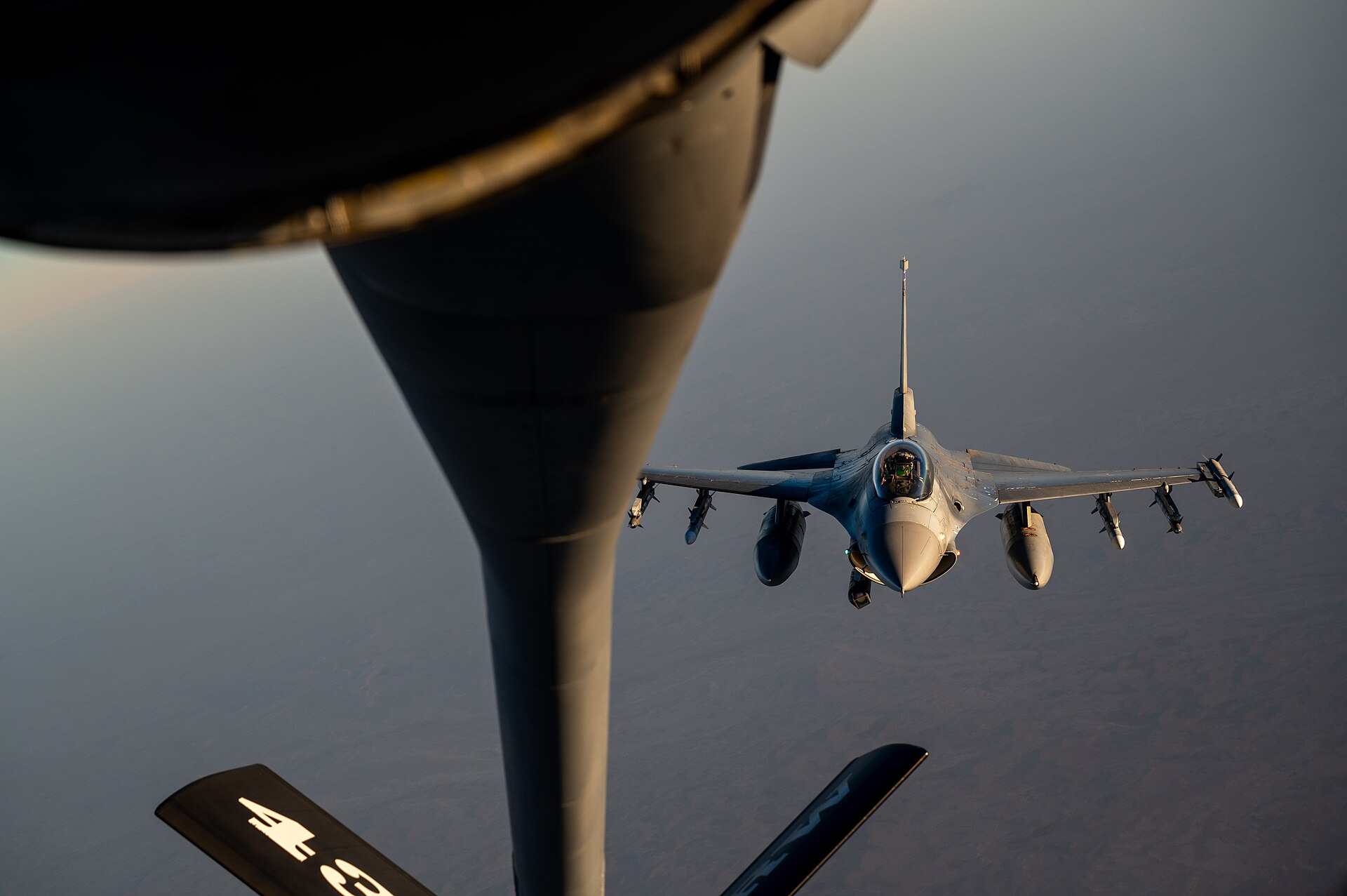 A USAF KC-135 Stratotanker extends its refueling boom toward an F-16 Fighting Falcon over the US Central Command area of responsibility, October 2024