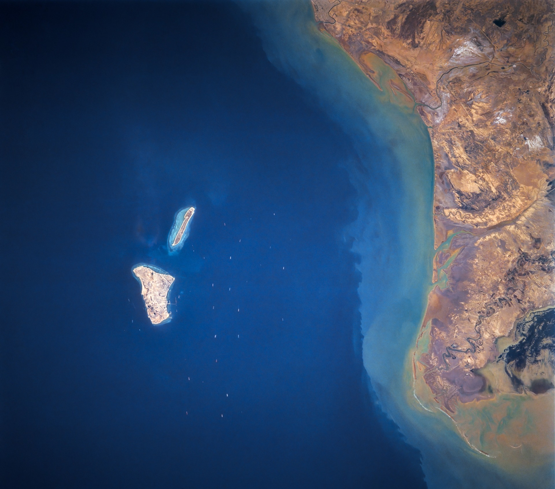 Kharg Island in the Persian Gulf — Iran's primary crude oil export terminal — with tankers visible in surrounding waters. NASA satellite photograph, Space Shuttle mission STS-055.