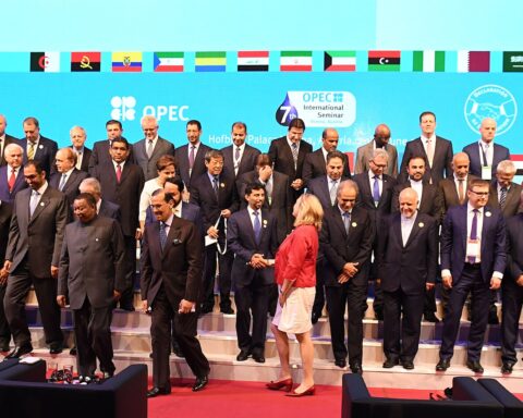 OPEC member-state energy ministers and delegates gather for the 7th OPEC International Seminar in Vienna, 2018, with national flags of all member countries displayed above the stage