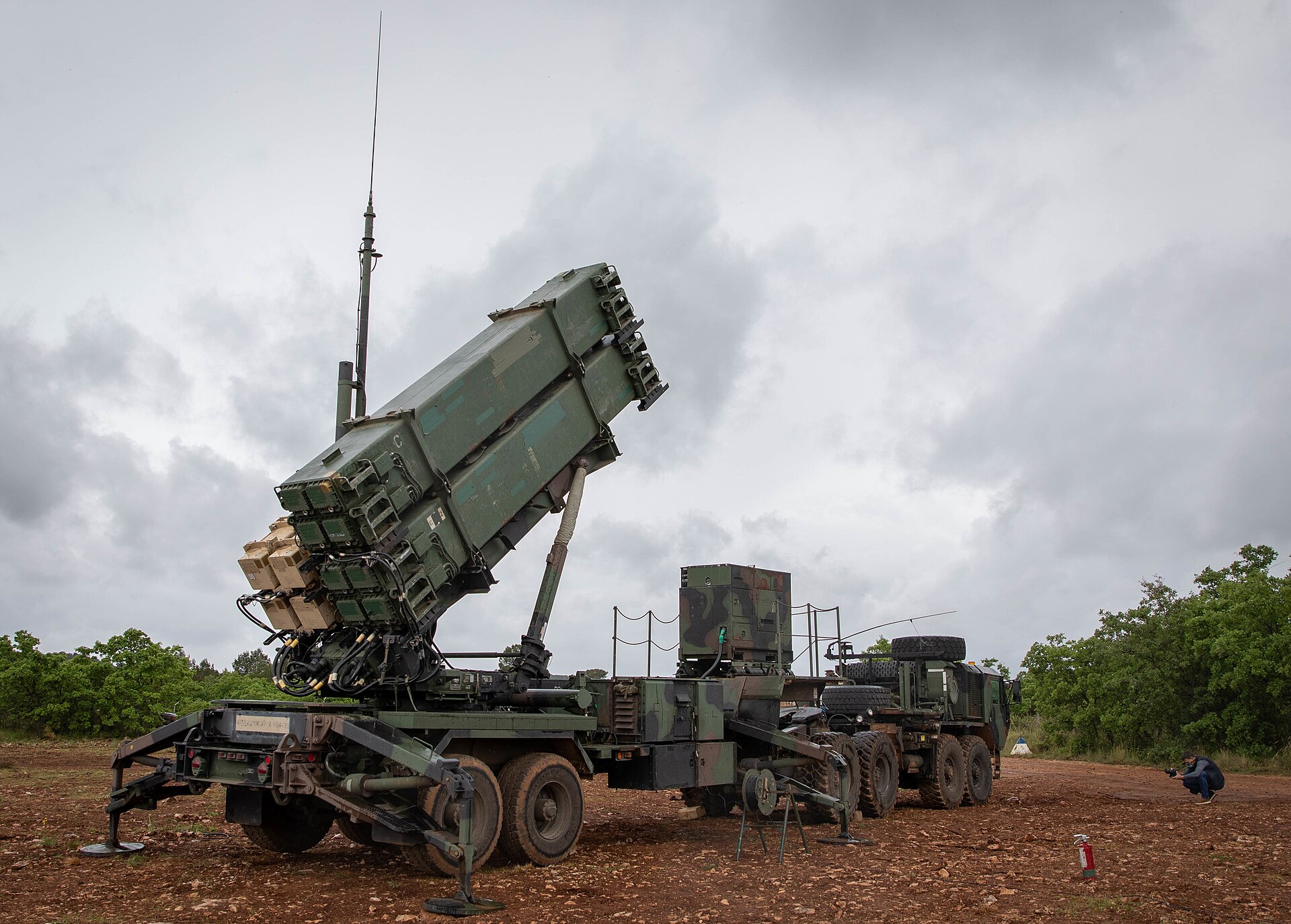 A US Army Patriot missile launcher in elevated ready position showing full interceptor canisters, part of the air defense artillery system deployed to protect against ballistic missile threats