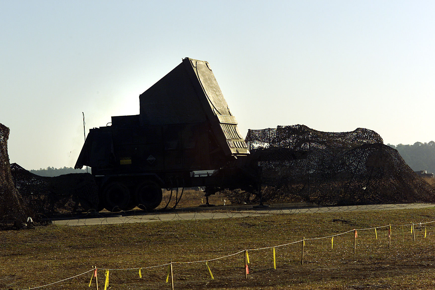 AN/MPQ-53 Patriot fire control radar phased array on trailer with camouflage netting — the single point of failure whose destruction mission-kills an entire Patriot battery